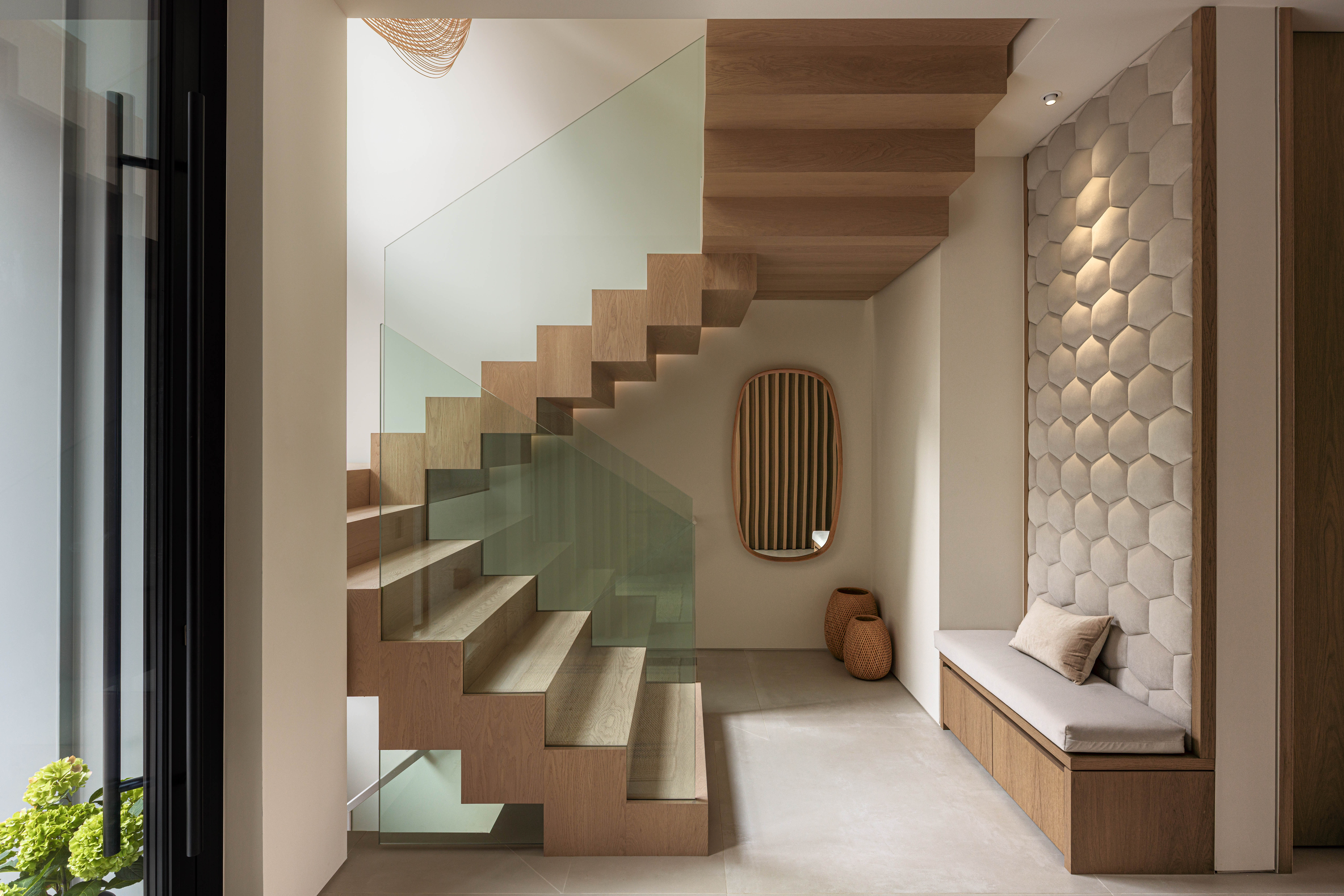 Fala custom home entrance with floating staircase, feature wall and built-in bench