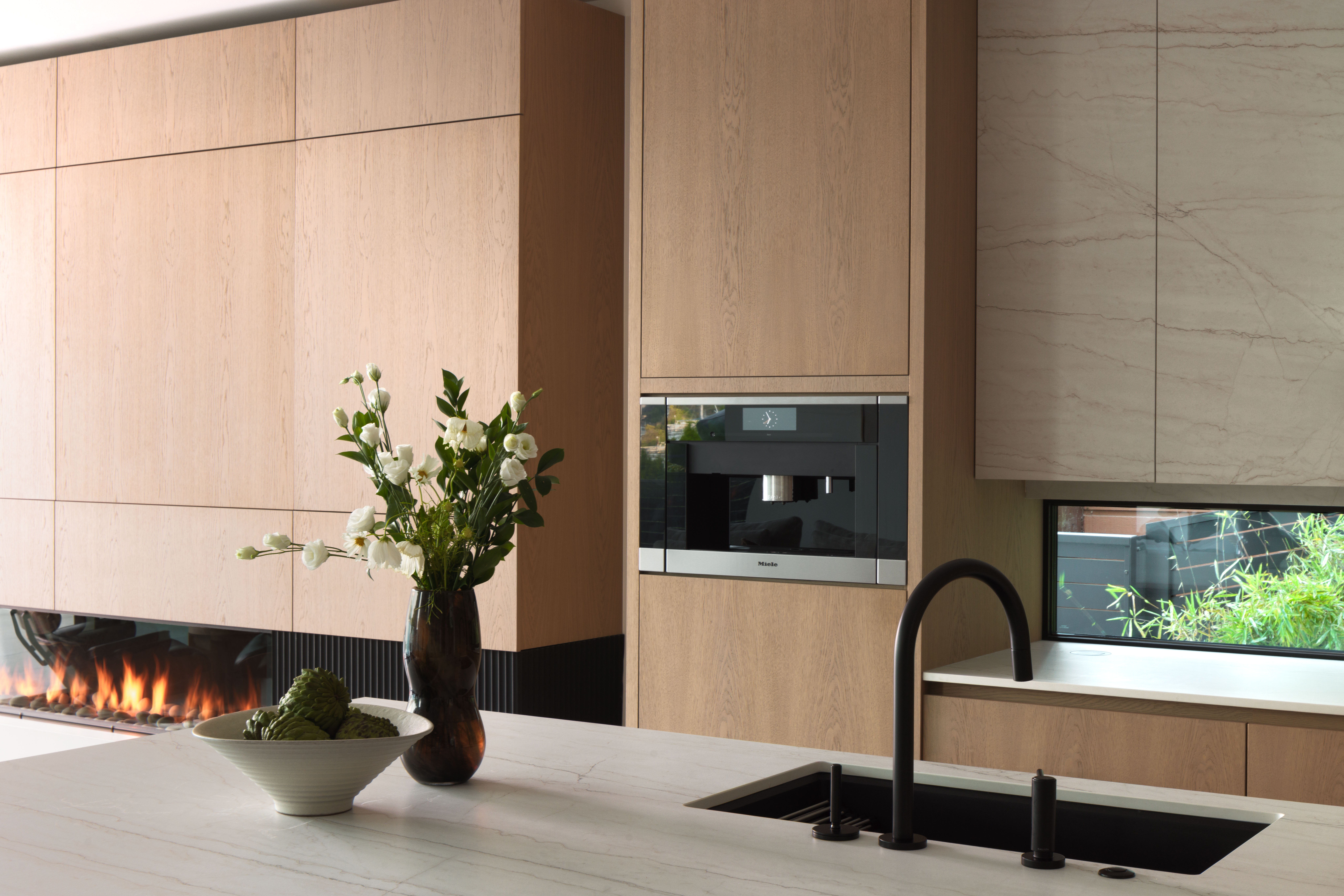 Fala custom kitchen island with custom wood cabinetry and built-in fireplace