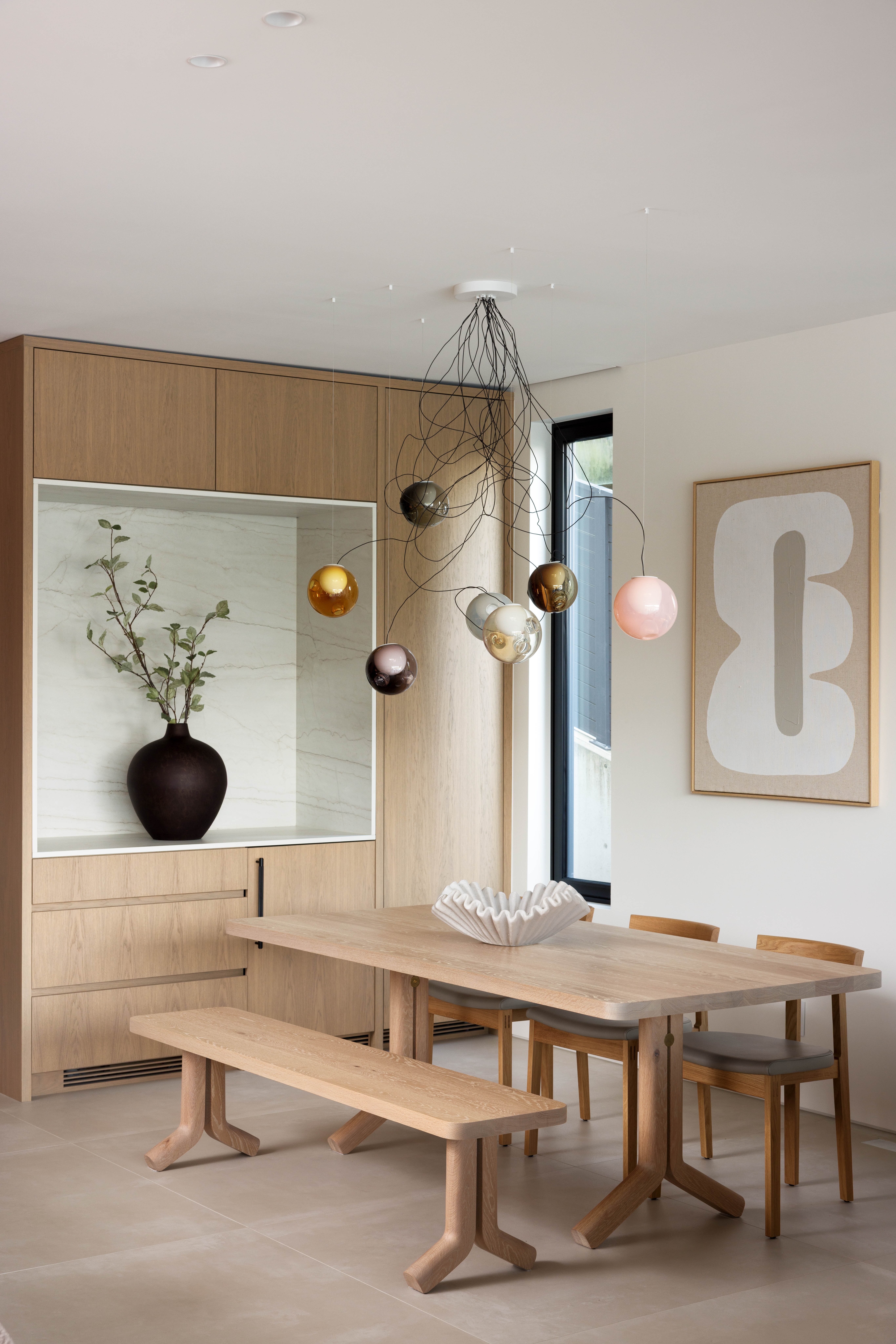 Fala custom dining area with feature light fixture and built-in cabinetry