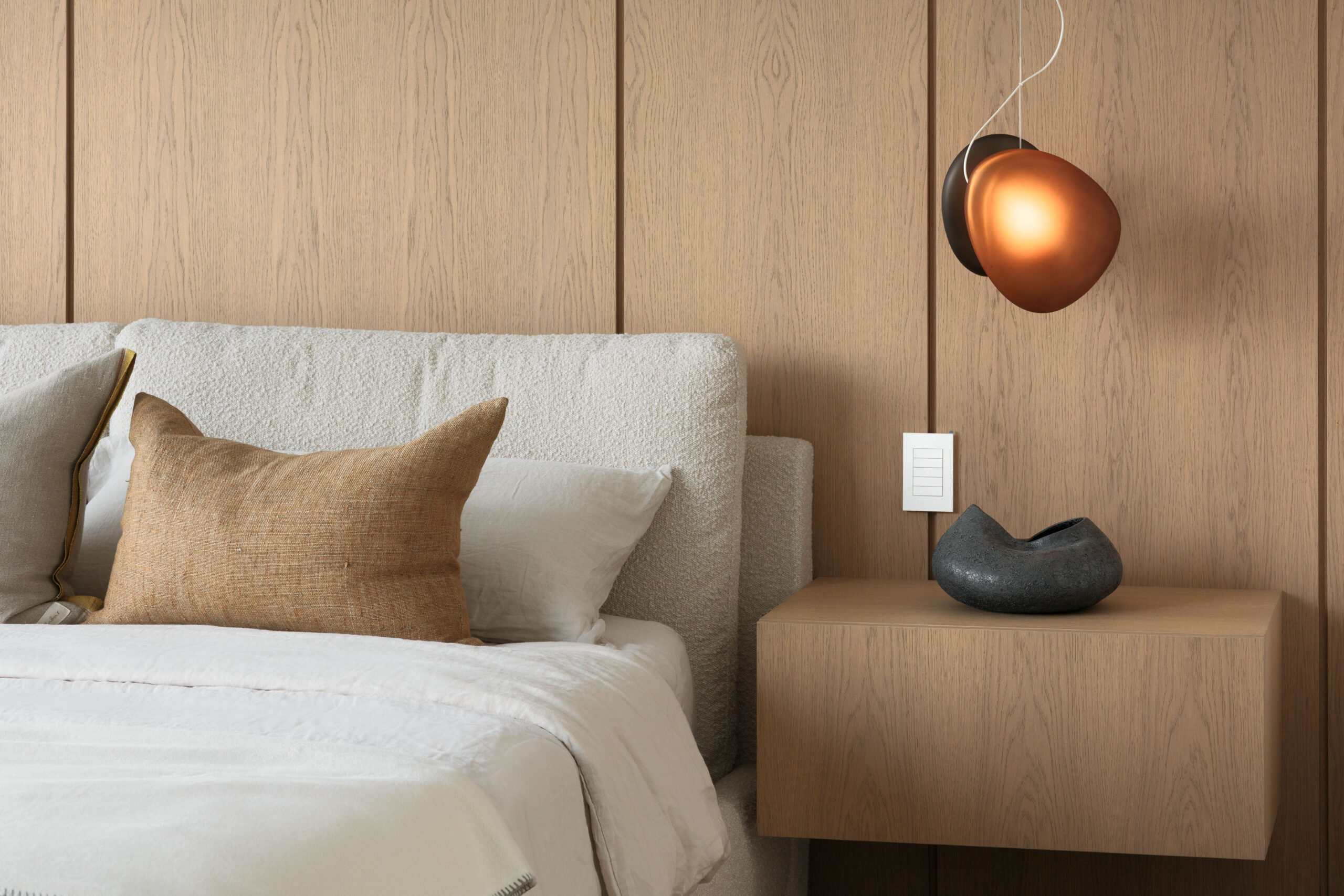 Fala primary bedroom with custom wood feature wall and bedside lighting