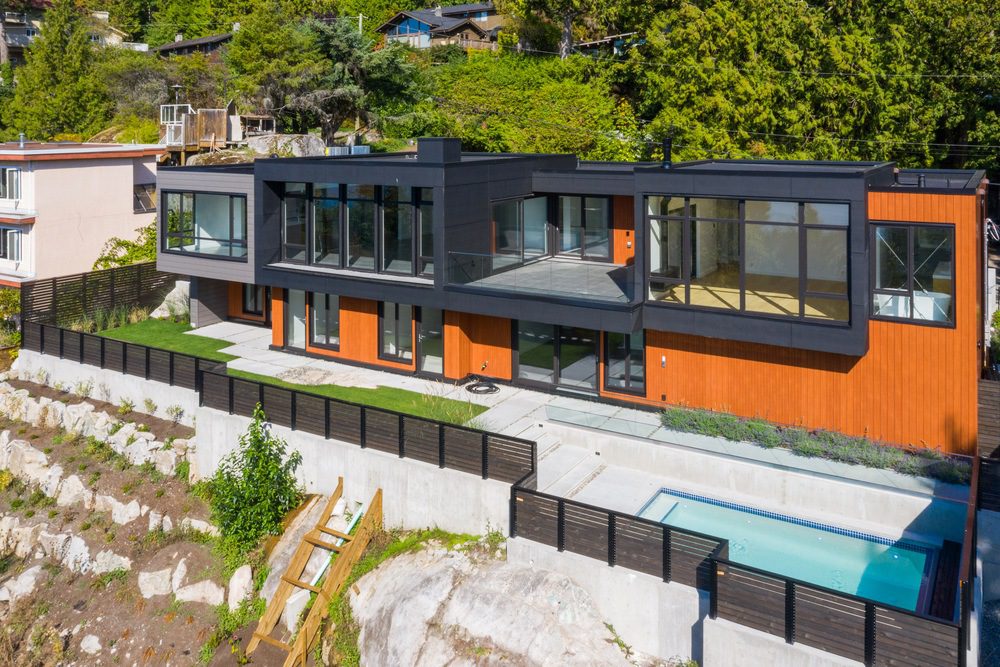 Duchess custom home built on a steep slope with exposed bedrock, outdoor terraces and a swimming pool.