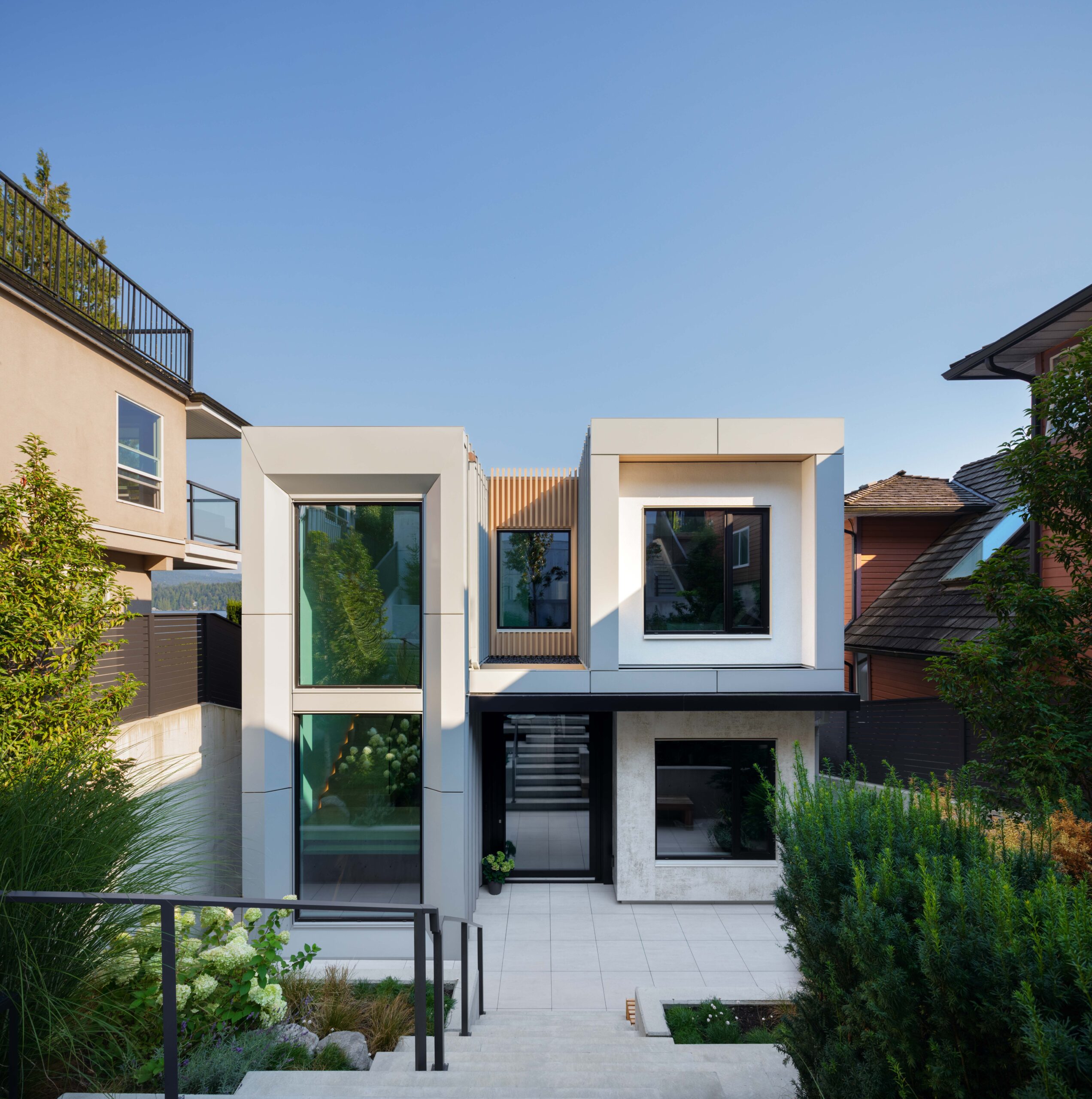 Front entrance of the completed Fala custom home in Deep Cove, North Vancouver, with modern architecture and landscaped steps.