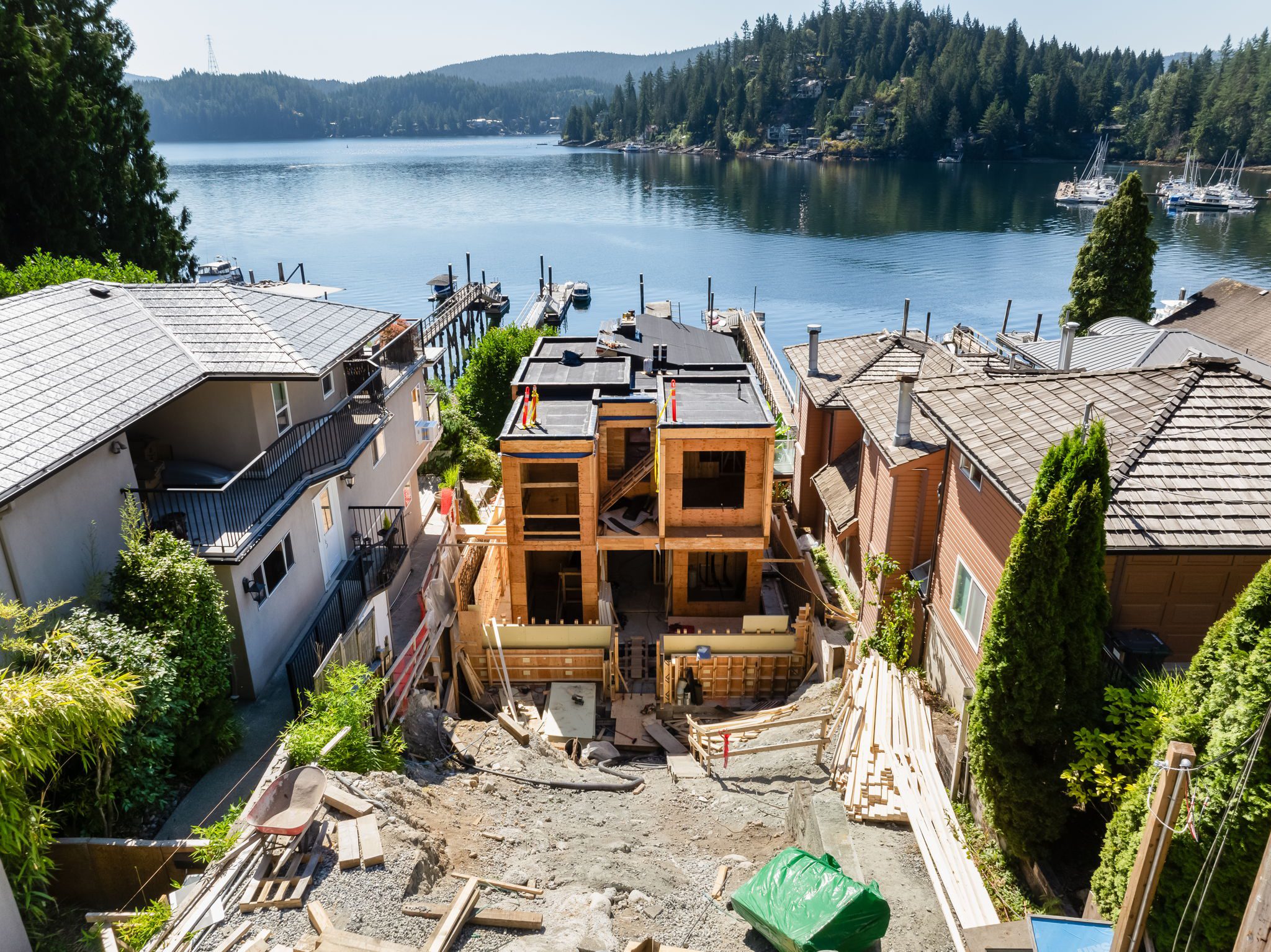 Building a house on a steep slope in North Vancouver, showing the Fala custom home under construction.