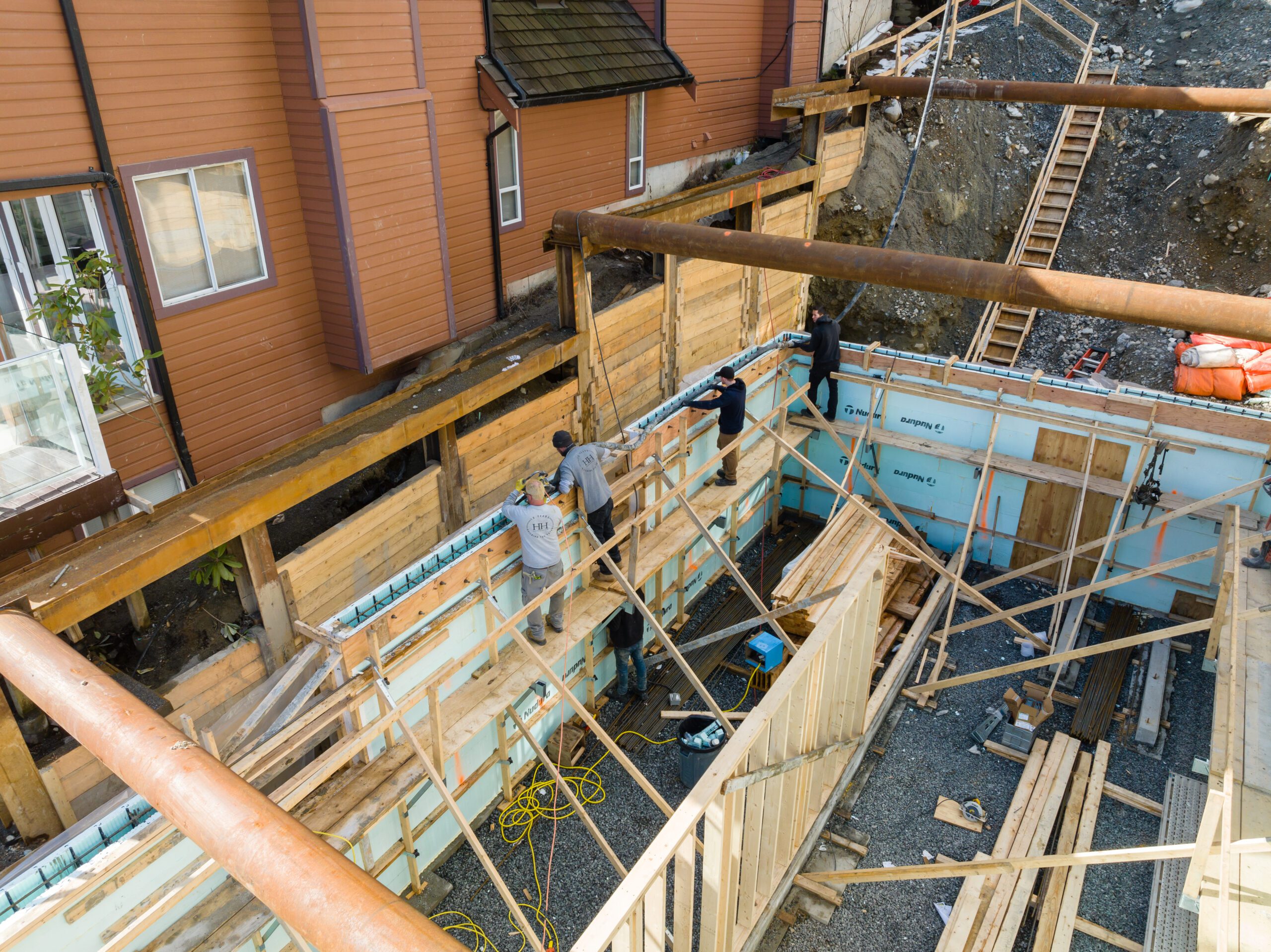 Hasler Homes construction crew working on foundation formwork at the Fala custom home in Deep Cove.